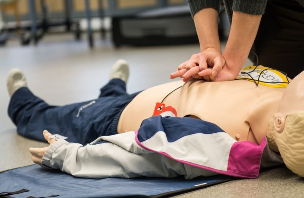 Persona aplicando una técnica RCP a un maniquí